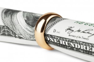 One hundred dollar bill in a gold wedding ring